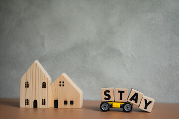 Miniature wooden houses with the words STAY. Concept of Coronavirus pandemic infection COVID-19.