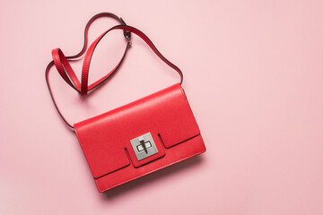 Red women's bag for special date on pink. Flat lay. View from above.