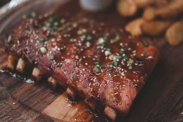 Pork ribs grilled with BBQ sauce on a wooden board