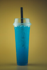Iced blue lime soda in tall plastic glass