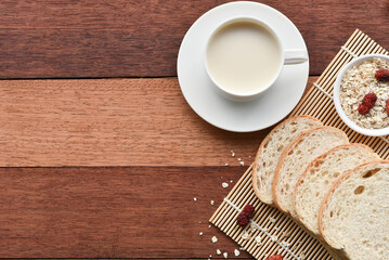 Milk and bread on wooden table in breakfast concept
