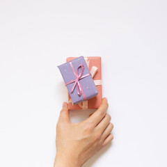 Hand holding gift boxes on white background. top view, copy space