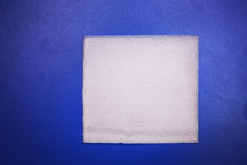 Blank paper napkin isolated on blue background with copy space . White napkin on blue background, many views of white napkins, blank mockup files .White Square Bar Napkin Isolated on blue Background .