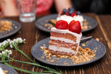 Sweet cakes with summer berries on a wooden table. Party, sweet table. Summer offer desserts in the restaurant.