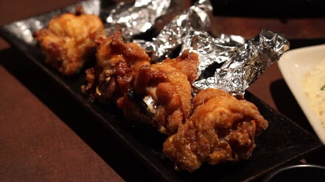 Fried chicken leg with foil over in restaurant