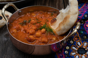 Indian chickpea garbanzo chole masala curry with naan in traditional bowls