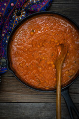 Indian chickpea garbanzo chole masala curry in cast iron pan, copy space