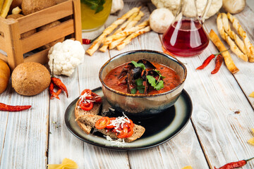 Tomato mussels soup with onion basil and toasts