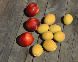 three nectarines and a few sweet peaches lies on a table