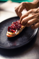 French baguette with hot Camembert cheese with jam in black plate