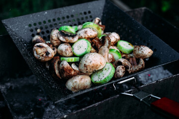 Mushrooms zucchini cook on a barbecue on the street