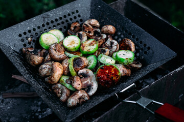 Mushrooms zucchini cook on a barbecue on the street