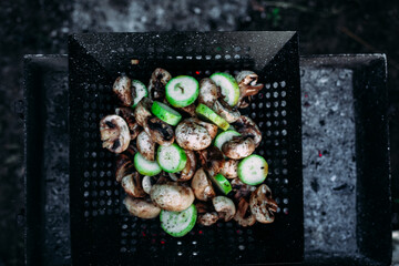 Mushrooms zucchini cook on a barbecue on the street