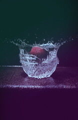 Cricket ball splash in bowl of water.