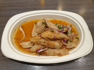 Hot and Spicy Grilled Pork Salad Nam Tok Moo on a white dish