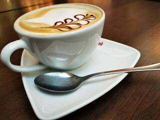 white cup of coffee with sme chocolate decorations