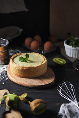 The process of making cheesecake with kiwi kurd. Ready dessert on the kitchen wooden table after cooking.