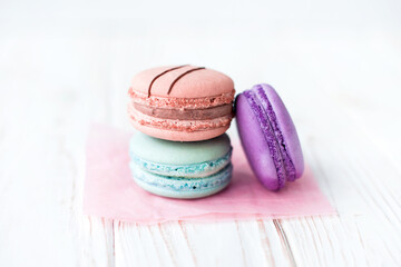 Close up view of three French macaroons on a white background. Sweet and colorful French macaroons. Dessert. Homemade sweets. Café dessert. Selective focus