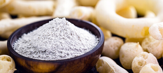 Brazilian manioc flour, called polvilho, manioc starch, carimã or gum, is the manioc starch. Rustic kitchen background with cookies around.