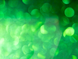 Fototapeta premium Abstract colorful green bokeh effect texture on black background. glitter vintage lights defocused elegant for Christmas or celebrate. Sparkling magical dust particles..