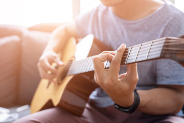 Working from home playing guitar learning online education video free time spending activity, self isolation quarantine lockdown staying safe in house living room protection from coronavirus covid-19