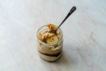 Creamy Peanut Butter Pie Dessert with Banana Slice and Chocolate Cake in Jar / Paleo Diet Cup.