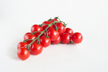 Two sprigs of cherry tomatoes on a light background