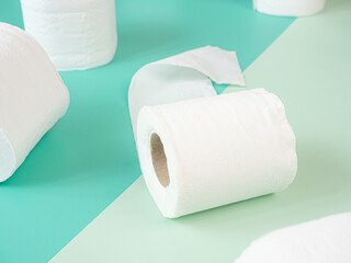 White Toilet Paper Rolls On pastel green background.