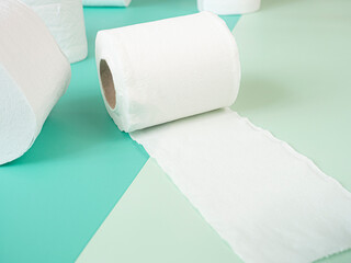 White Toilet Paper Rolls On pastel green background.