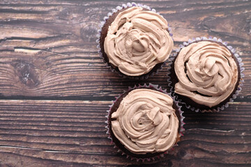 Top view of chocolate cup cake on wooden table.