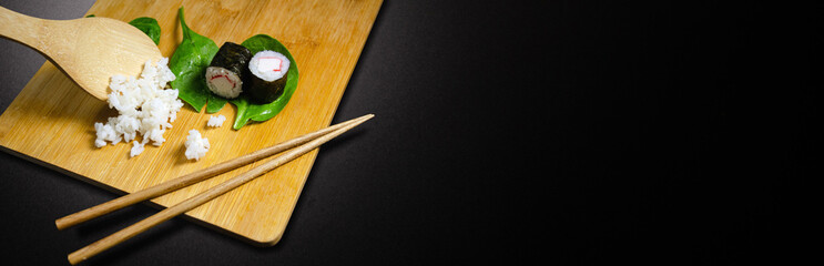 Maki Surimi Sushi On Wood Cutting Board With Rice And Baby Spinach