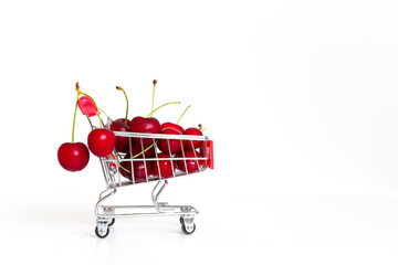 Red cherries in a shopping cart. White background.