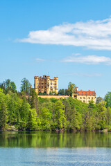 View of Hohenschwangau Castle from the lake on a sunny day. Germany, Bavaria, Schwangau.