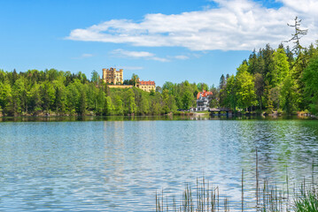 Fototapeta premium View of the Hohenschwangau Castle. Panorama from the side of the lake on a sunny day. Germany, Bavaria, Schwangau