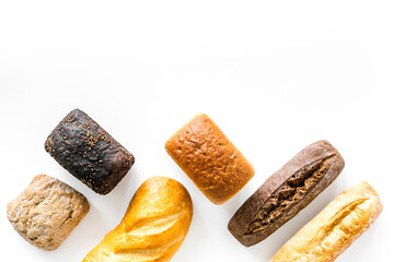 Different kinds of fresh bread on kitchen table top view space for text
