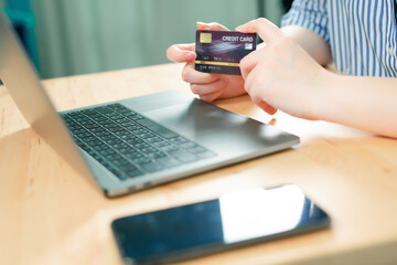 beauty woman hand hold credit card and use laptop for shopping and check discount sale from her home
