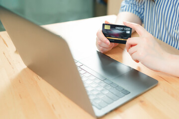 beauty woman hand hold credit card and use laptop for shopping and check discount sale from her home