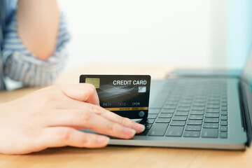 beauty woman hand hold credit card and use laptop for shopping and check discount sale from her home
