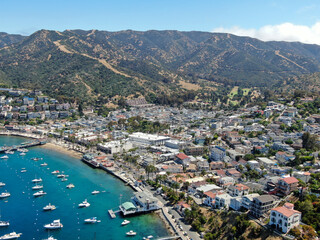 Aerial view of Avalon harbor in Santa Catalina Island with sailboats, fishing boats and yachts moored in calm bay, famous tourist attraction in Southern California, USA