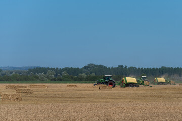 heavy machinery in the field performs agricultural work during the summer