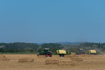 Obraz premium heavy machinery in the field performs agricultural work during the summer