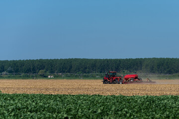 heavy machinery in the field performs agricultural work during the summer