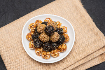 Sesame seeds balls - sweet made with sesame and palm sugar. Tilgul Laddu or Til Gul balls for makar sankranti, Roasted thala balls. Indian snacks