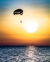 Man parachutes on the background of the sea and colorful sunset in Sochi, Krasnodar Krai, Russia