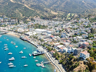Fototapeta na wymiar Aerial view of Avalon harbor in Santa Catalina Island with sailboats, fishing boats and yachts moored in calm bay, famous tourist attraction in Southern California, USA