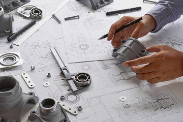 Engineer technician designing drawings mechanical parts engineering Engine.manufacturing factory Industry Industrial work project blueprints measuring bearings caliper tools