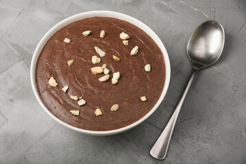 Ragi Porridge, Sweet Ragi Malt, Java healthy nutritional drink made from organic finger millet flour in a bowl garnished with crushed dry fruits,  Kerala, India. Top view Indian food white background.