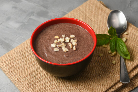 Ragi Porridge, Sweet Ragi Malt, Java healthy nutritional drink made from organic finger millet flour in a bowl garnished with crushed dry fruits,  Kerala, India. Top view Indian food white background.