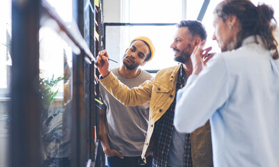 Professional male project manager making consultancy meeting with staff members presenting creative solution of problems with law income while collaboration on advertising campaign for company