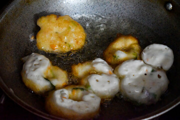 south indian cuisine - Vada or Medu vadai frying in coconut oil. Very popular south Indian snack.